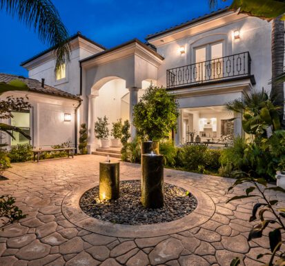 Modern house with a front yard fountain illuminated at night