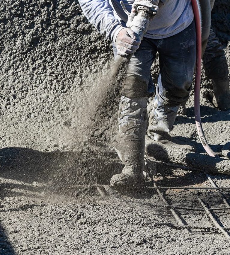 Pool Construction Worker Shooting Concrete, Shotcrete or Gunite Through Hose