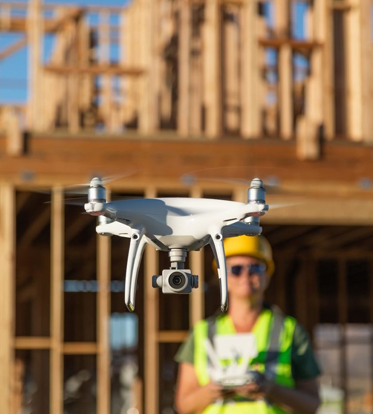 Female Pilot Flies Drone Quadcopter Inspecting Construction Site.