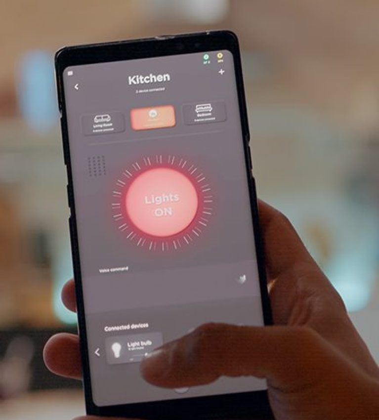 Man using smart home app touching screen to turn on light by phone