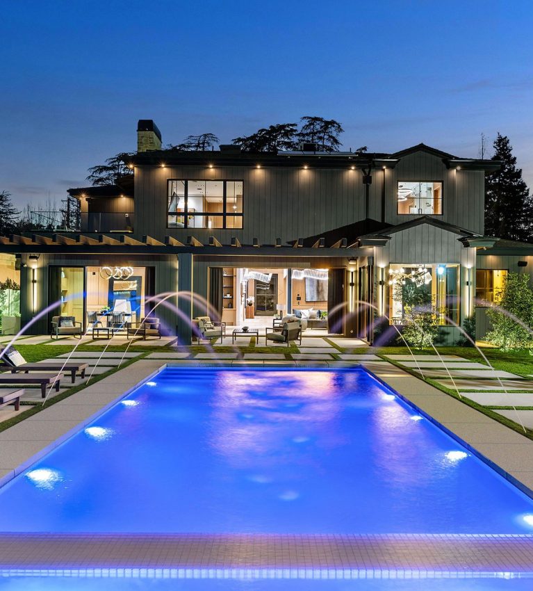 Luxurious modern house with a swimming pool at twilight.