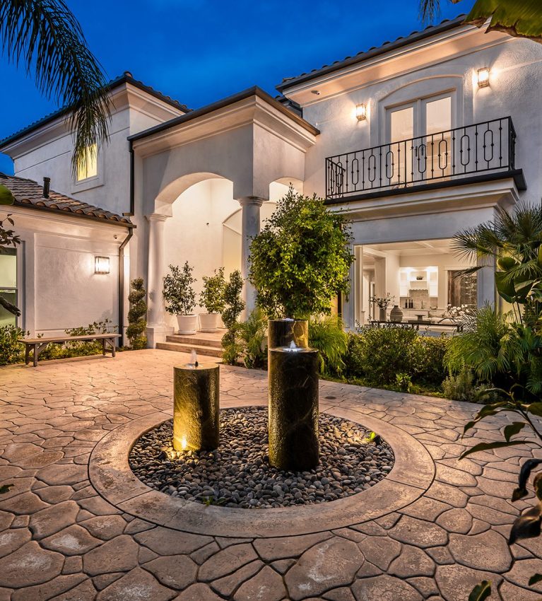 Modern house with a front yard fountain illuminated at night